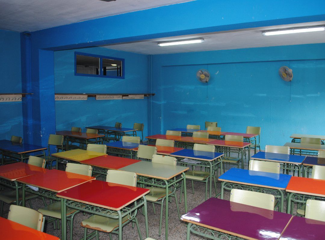 clase con mesas de colores y pared azul